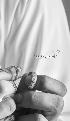 a woman holding onto her wedding ring with the word love in arabic written on it