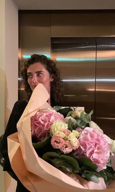 a woman holding a large bouquet of flowers