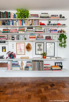 the bookshelf is filled with many different types of books and plants on it