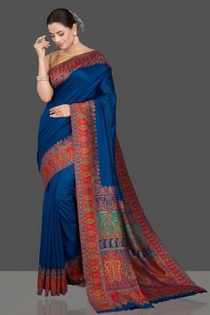 Shop beautiful indigo blue silk saree online in USA with red Kani embroidery border. Get ready for festive occasions and weddings in tasteful designer sarees, Banarasi sarees, handwoven sarees from Pure Elegance Indian clothing store in USA.-full view Blue Kalamkari Pre-draped Saree For Diwali, Blue Semi-stitched Saree With Kalamkari Print, Blue Silk Traditional Wear With Printed Border, Blue Kalamkari Print Saree, Blue Katan Silk Saree With Kalamkari Print, Blue Banarasi Silk Traditional Wear With Printed Border, Blue Kalamkari Print Unstitched Saree, Unstitched Blue Kalamkari Saree, Blue Kalamkari Print Saree For Wedding