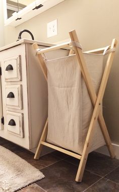 a laundry hamper sitting on top of a wooden stand