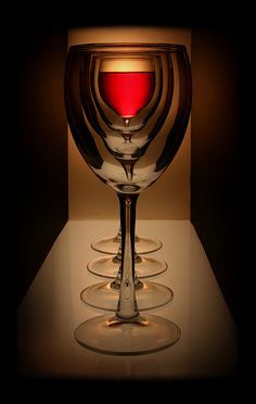 a lit up wine glass sitting on top of a table