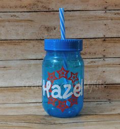 a blue mason jar with a straw in it and the word hazel painted on it