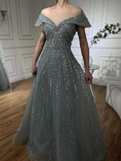 Elegant A-line silhouette for a flattering and timeless fit Luxurious gray hue exudes sophistication and modern elegance Intricate beaded design adds opulence and sparkle to the gown Crafted from high-quality fabrics for comfort and a regal appearance Perfect for formal Saudi events, weddings, and upscale gatherings Floor-length design creates a graceful and grand presence Figure-flattering bodice enhances the natural curves Ideal for women seeking a blend of traditional Arabic style with contem Arabic Style, Grey Beads, Natural Curves, Contemporary Fashion, Modern Elegance, Evening Gown, Formal Occasion, Floor Length, Evening Gowns