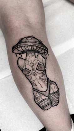 a black and white photo of a person's leg with a mushroom tattoo on it