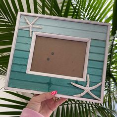 a person holding up a frame with starfish on it