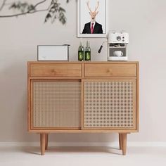 an image of a deer on the wall next to a wooden cabinet with two bottles and a coffee maker