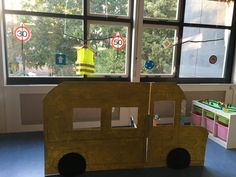 a wooden toy bus sitting in front of a window