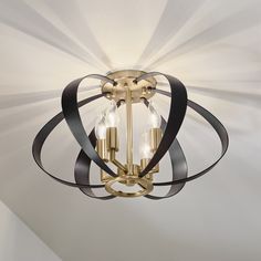 a chandelier with three lights hanging from it's center and black ribbons on the ceiling