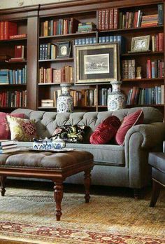 a living room filled with lots of bookshelves next to a couch and coffee table