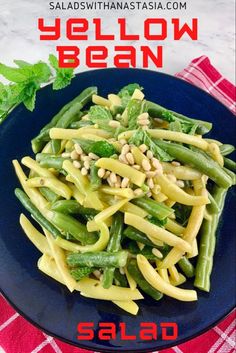 a blue plate topped with pasta and green beans