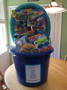 a blue bucket filled with toys sitting on top of a wooden table