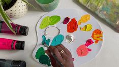 an artist's palette with paint, brushes and other art supplies on a table