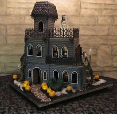 a cake that is shaped like a house with pumpkins on the roof and windows