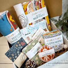 an open box filled with lots of different types of wrapping paper on top of a wooden table