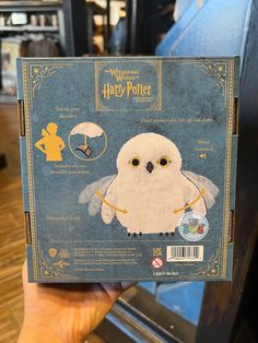 someone holding up a harry potter book with an owl on it