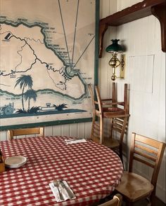 a dining room with a map on the wall and table cloths set for four