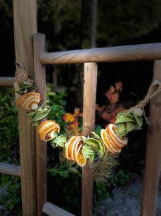 an orange and green garland hanging from a wooden fence