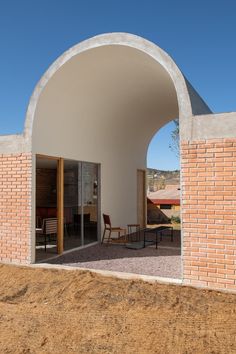 an arch in the side of a building with chairs and tables on top of it