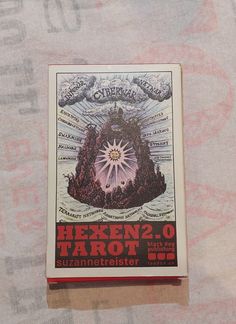 an old book is laying on a bed sheet with the title hexen 2 0 tarot written below it