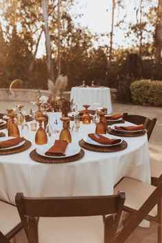 the table is set with plates and place settings