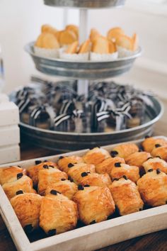 there are many pastries in the trays on the table next to each other