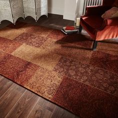 a living room area with a red chair and brown rug on the wooden floor next to a radiator