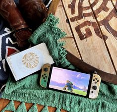 a nintendo switch sitting on top of a wooden table next to a book and other items