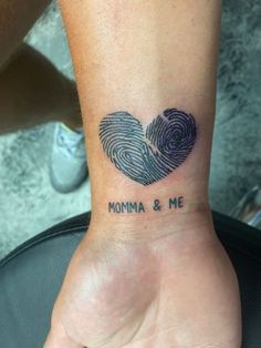 a woman's wrist with a fingerprint in the shape of a heart that says momma and me