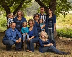 a group of people are posing for a family photo