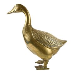 a brass duck statue sitting on top of a white surface