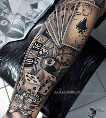 a man's arm with playing cards and dice tattoos on his arm, while he is