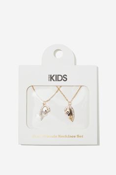 two necklaces in the packaging for kids's jewelry, one with an angel wing and