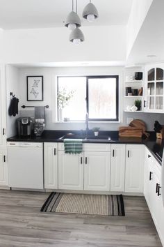 the kitchen is clean and ready for us to use it's white cabinets with black counter tops