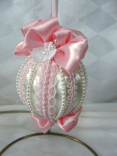 a pink and white ornament hanging from a metal ring on a table top