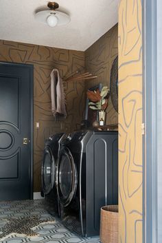 a washer and dryer in a room with patterned wallpaper on the walls