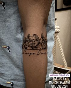 a man's arm with flowers and the words carpo diero tattooed on it