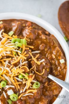 a white bowl filled with chili and cheese