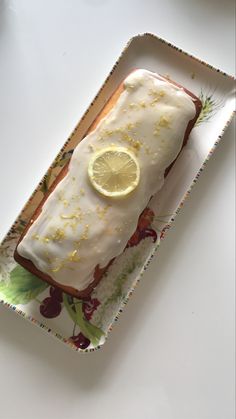 a piece of cake sitting on top of a plate with lemons and icing