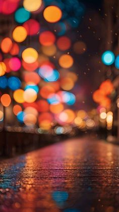 blurry image of colorful lights in the city at night with rain falling on the ground