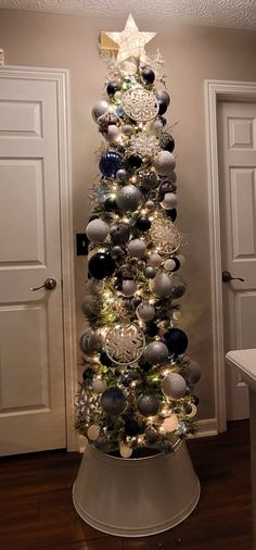 a christmas tree with ornaments and lights in the shape of an ornament on top