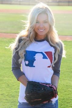 a woman standing on top of a baseball field holding a catchers mitt