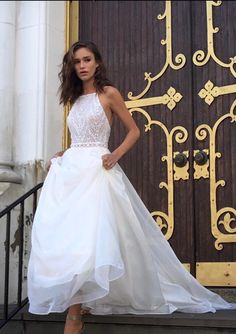 a woman in a white dress is standing on the steps near a door and wearing heels