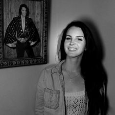 a black and white photo of a woman in front of a portrait