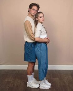 a man and woman standing next to each other on a hard wood floored floor