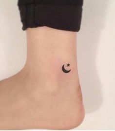 a small black crescent and star tattoo on the right side of the ankle, which has a tiny white dot in the middle