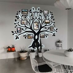 a dining room table with chairs and a tree wall hanging on the wall above it