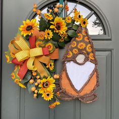 a wreath with sunflowers and a bird on it is hanging on the front door