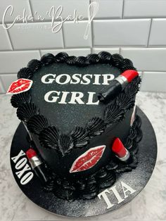 a black cake decorated with lipstick and the words gossip girl