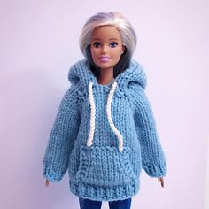 a doll is wearing a blue sweater and jeans